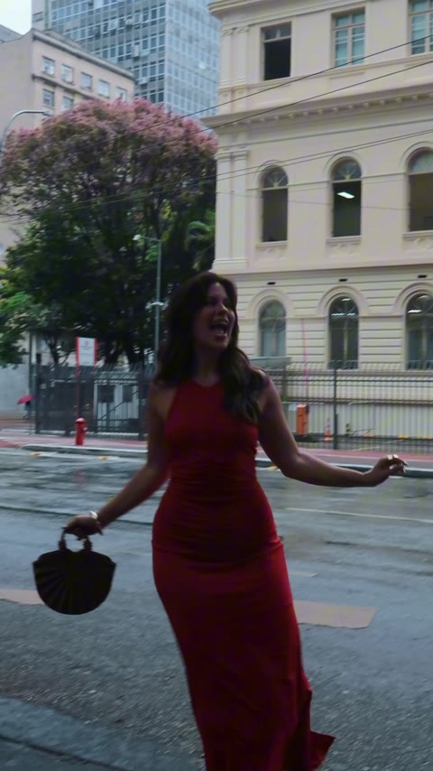 Look com vestido vermelho e acessórios em um cenário urbano